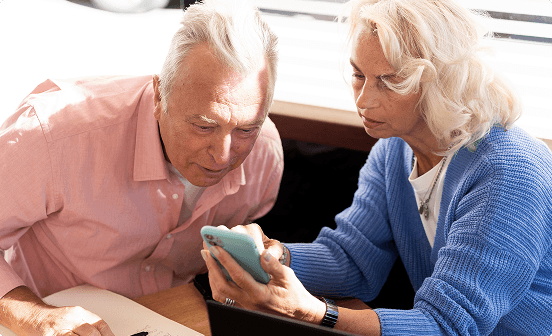 An older couple looking at a phone together